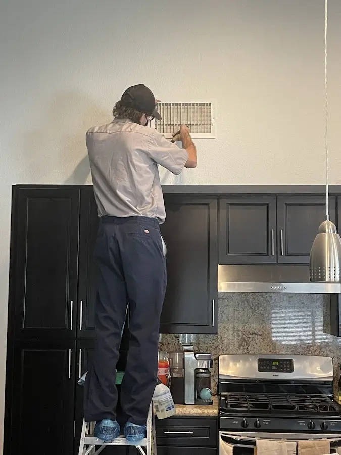 Technician inspecting an air vent during HVAC service in Cocoa West